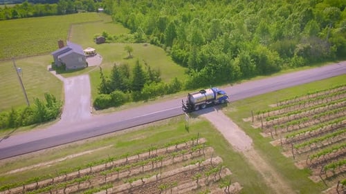 A country road being paved by a construction crew on a hot summer day