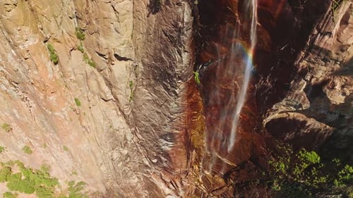 Almost dried waterfall with water spraying in the wind and creating rainbow. Cliffs of Yosemite