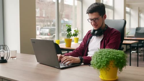 Camera Flies Around Developer Writing Program Code on Computer Display Alone in Office Freelancer