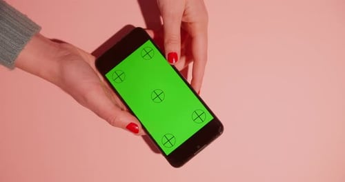 Mujer usando el teléfono móvil, fondo rosa
