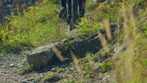 A mountain biker hops over a sharp rock in slow motion