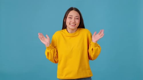 Woman Shrugging Shoulders and Saying Oops on Blue Background
