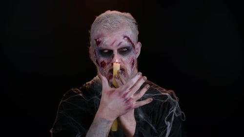 Man with Zombie Make Up Holding Candle