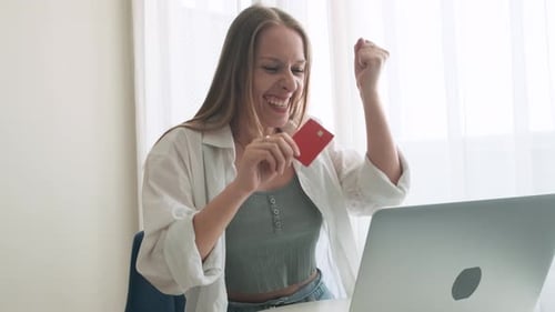 Happy Caucasian Woman Using Laptop for Online Shopping with Credit Card at Home Excited Female