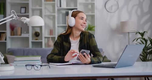 Teen Girl School College Student wear Headphones Hold Mobile Phone Distance Learning Online. Female