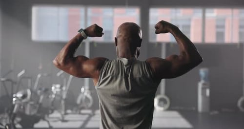 Exercise, black man and back view of flexing biceps, bodybuilder and fitness in gym