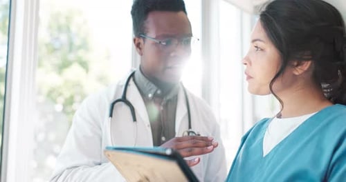 Doctor and Nurse Discussing Patient Data on Tablet