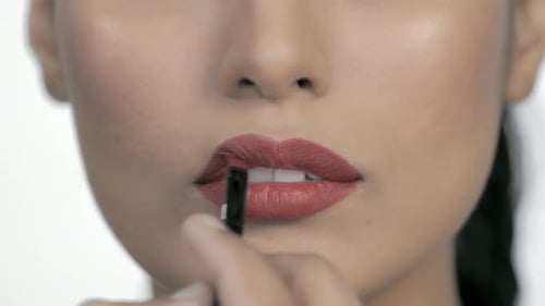 Woman Applying Lipstick with Brush, Close Up