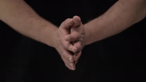 Hands Open and Clasping Against Black Background