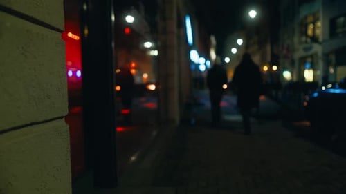 Imagens desfocadas de pedestres na rua da cidade à meia-noite com iluminação automotiva