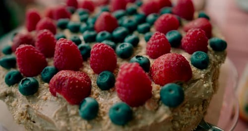 Close up shot of the fresh delicious cake with strawberries and blueberries toppings