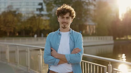 Caucasian Handsome Smiling Man Standing Outside the Street Crossing Hands and Looking at the Camera