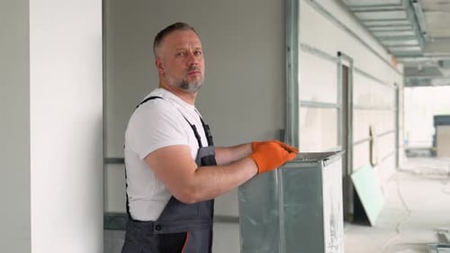 Worker Holding Ventilation Pipe for Installing in the Commercial Building Ventilation System Purity