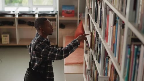 Black Man Browses for Book on Library Shelf