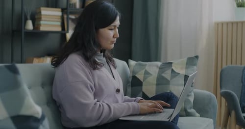 Young Woman Working on Laptop at Home