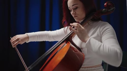 Woman Plays Cello with Focused Expression