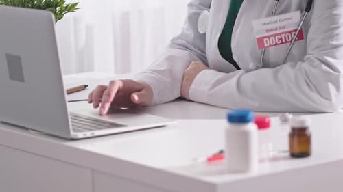 Doctor Typing on Laptop at Medical Workplace