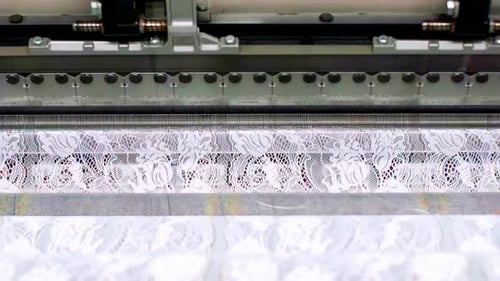 Close up of textile weaving white lace fabric in factory