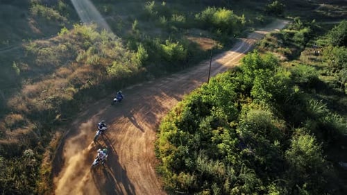 Aerial drone view of motorcyclists jumping from springboards at a motocross race, mud track, rally m
