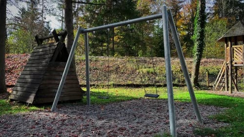 Empty children playground with swing in park.