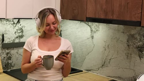 Woman in Kitchen Listening to Music and Drinking Coffee
