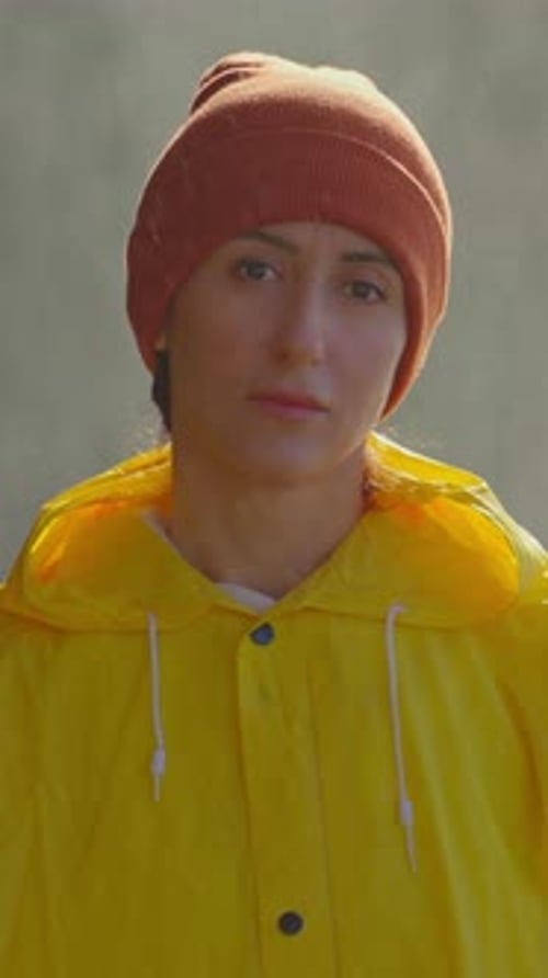 Woman in Yellow Raincoat and Knit Hat Portrait