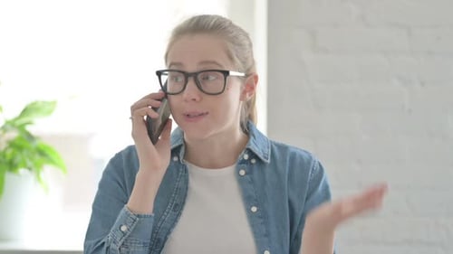 Frustrated Woman Talking on Phone Indoors