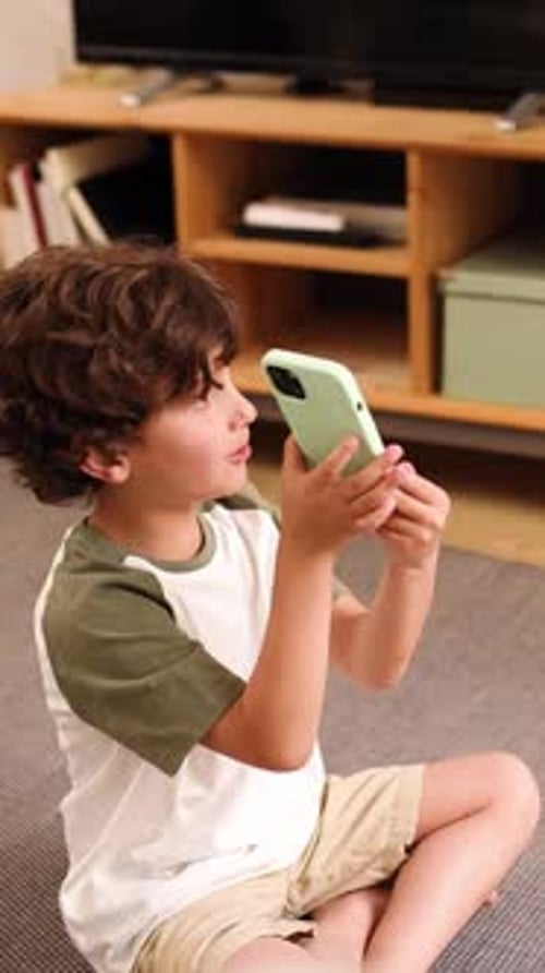 Boy Sits on Floor Using Phone
