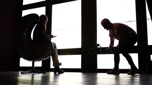 Video production team with model and male with camera in bright studio