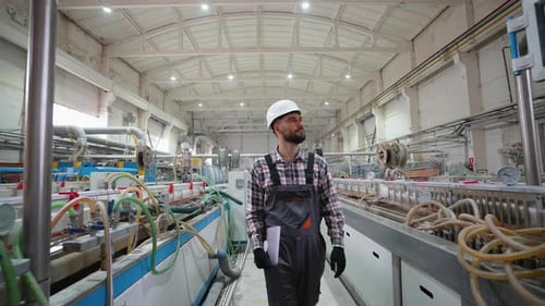 Industrial Engineer Walking and Inspecting Modern Automated Production Line