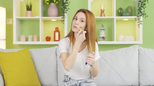 Woman Applying Makeup with Brush in Home Interior