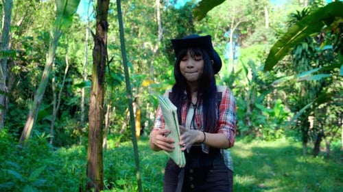 Asian teenager woman travel backpack looking map for direction of destination of journey adventure.