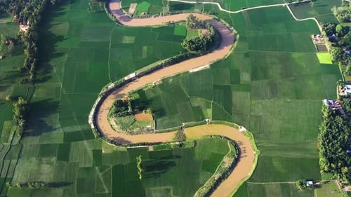 Aerial view of river winding through green fields, Bangladesh.