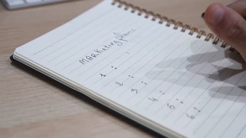 Hand Writing Marketing Plan Notepad Close Up