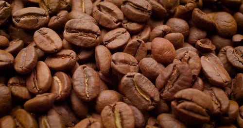 Gros plan sur des graines de café. Les grains de café parfumés sont torréfiés. La fumée provient des grains de café.