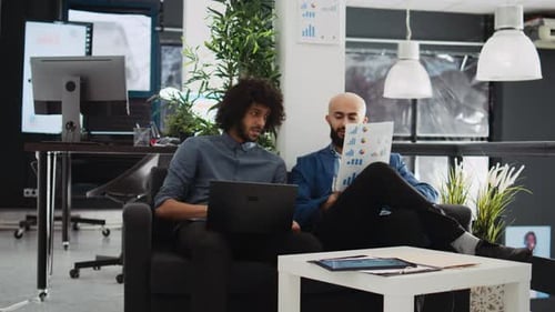 Two Young Adults Collaborate on a Laptop