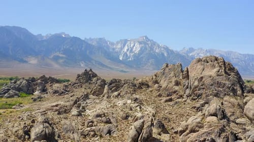 Vue aérienne 4K de rochers près d'Alabama Hills avec le mont Whitney en arrière-plan, en Californie, États-Unis.
