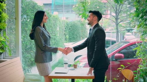 Business Handshake Between Woman and Man in Cafe
