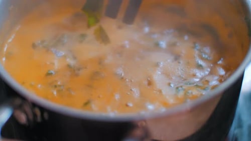 Frau rührt leckere und würzige asiatische Tom Yam-Suppe