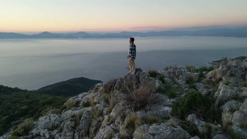 Man Standing on the Top of the Mountain Enjoying Scenery Sunset Over Sea