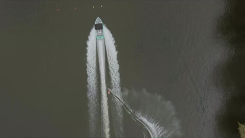 Aerial headshot of Wakeboarder Towing Boat on the river. riding board speedboat.