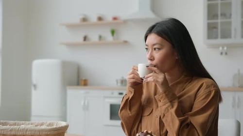 Woman Enjoys Coffee in Bright Modern Kitchen