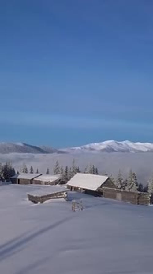 Stunning Aerial View of Snowcovered Cabins Amidst Winter Landscape