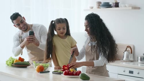 Family Enjoys Cooking Together in a Bright Kitchen with Fresh Vegetables