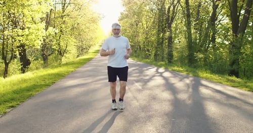 Caucasian Happy Senior Retired Sportsman Jogging Outdoors Alone on Street Greyhaired Old Male