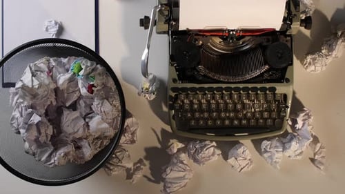Typewriter with Crumpled Paper in Trash Bin Overhead