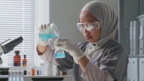 Woman Scientist Working in Laboratory with Chemical Liquids