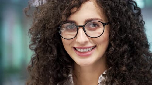 Close up face of smiling beautiful businesswoman in modern glass business office. Portrait of happy