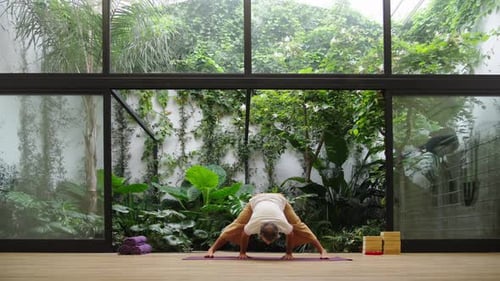 Man practicing meditation pose in green garden with serene focus