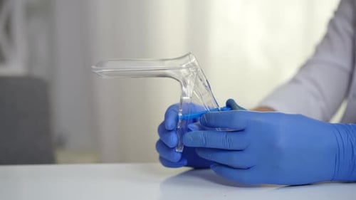 Closeup Hands of Gynecologist in Gloves Holding Cusco Vaginal Speculum